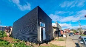 Casa de dos pisos con revestimiento metálico negro
